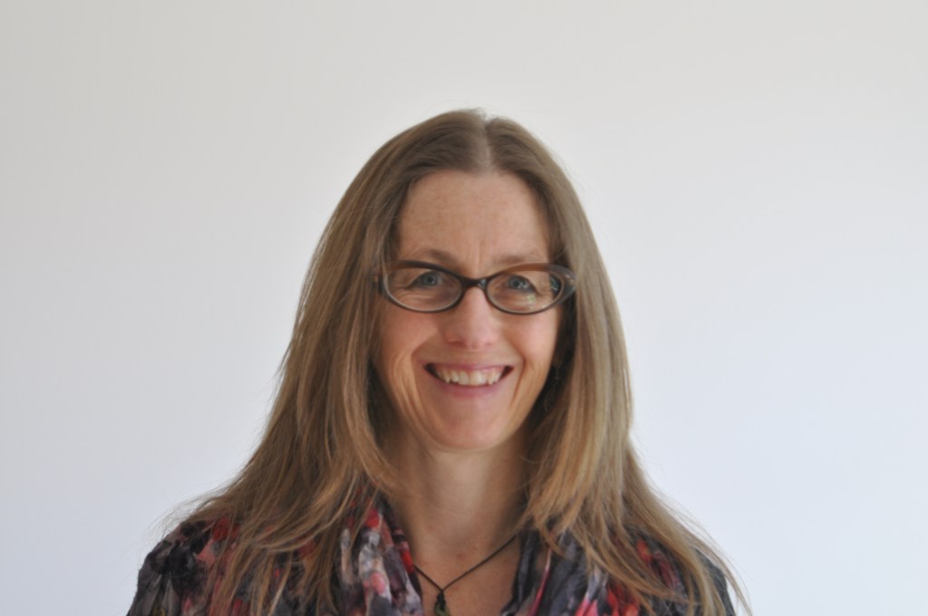 Image of Carolyn smiling at the camera with a blank background.